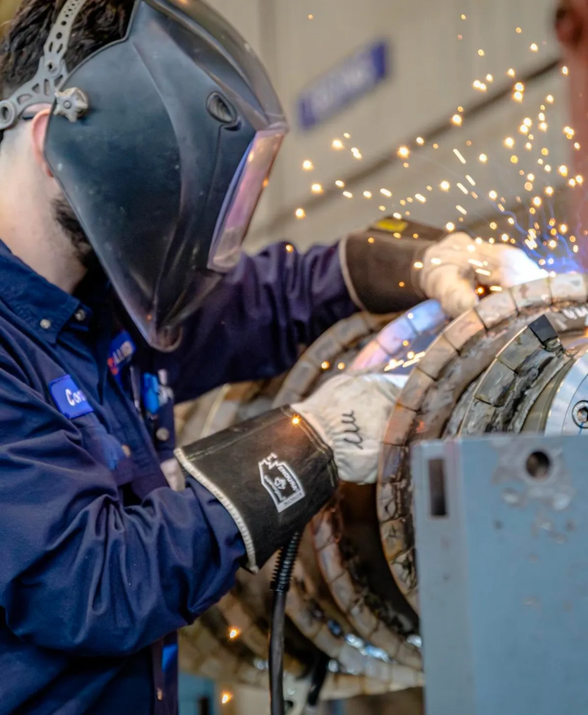 KMS technician welding a centrifuge component during repair